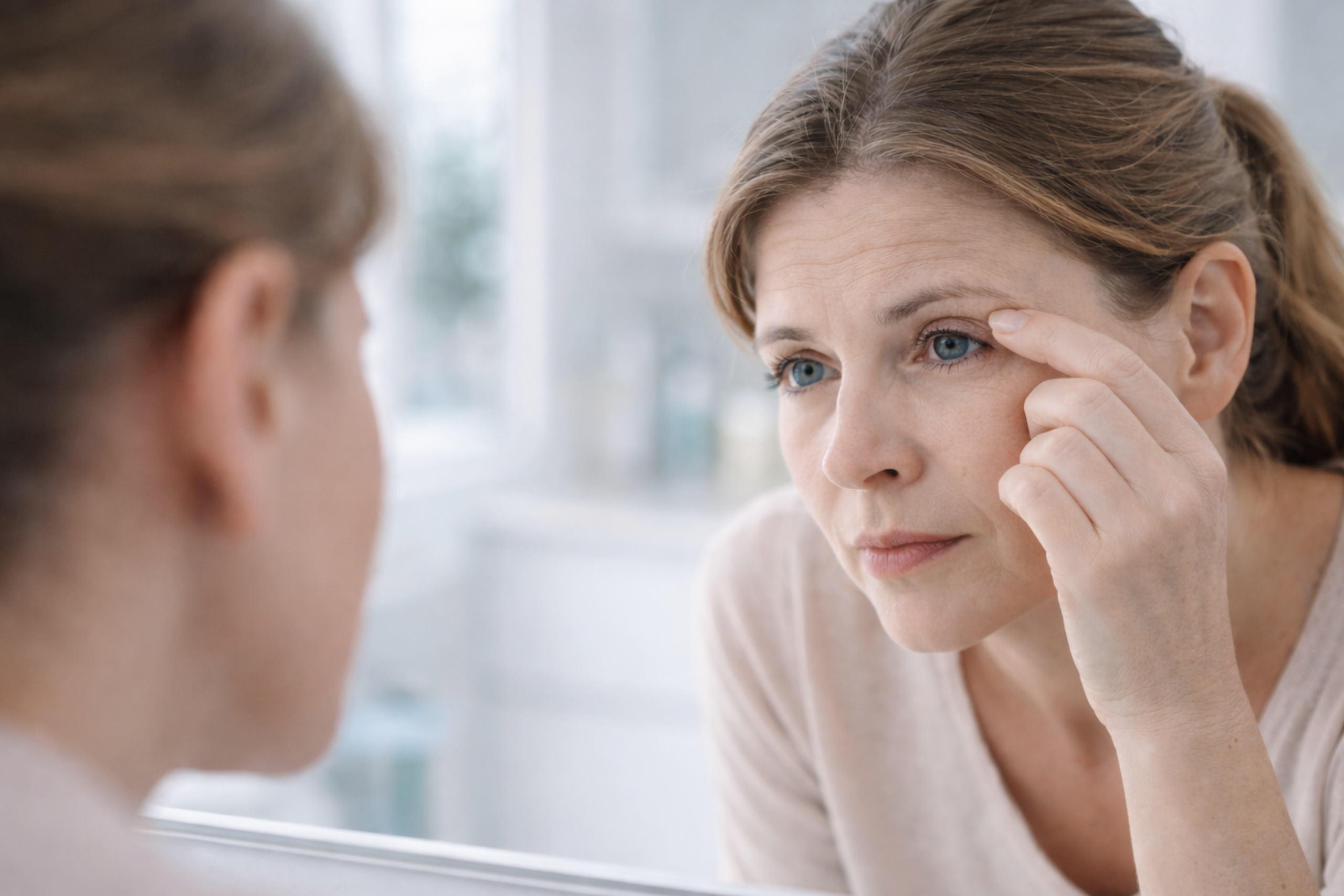 Egy nő apró kinövést vizsgál a szemén